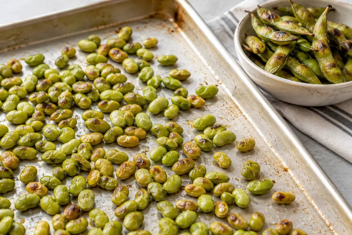 Roasted shelled edamame on a tray beside roasted pods Roasted shelled edamame on a tray beside roasted pods
